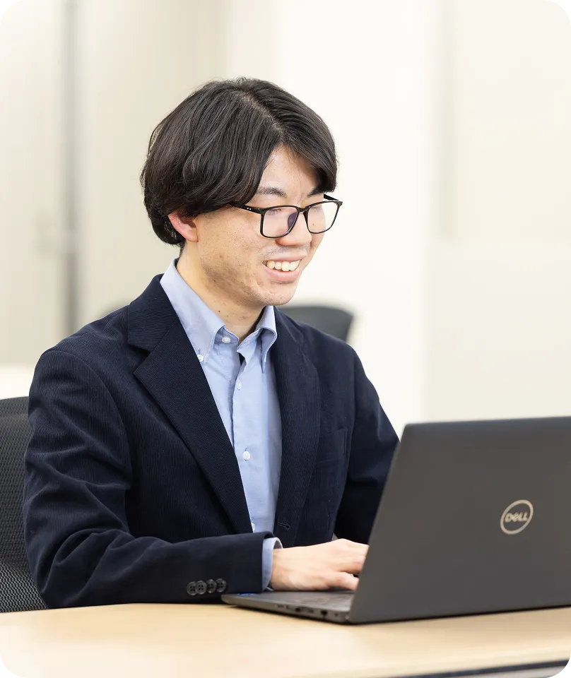 笑顔でパソコン操作をする男性社員